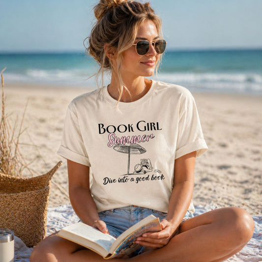 Woman on a beach wearing a 'Book Girl Summer' t-shirt, holding a book.