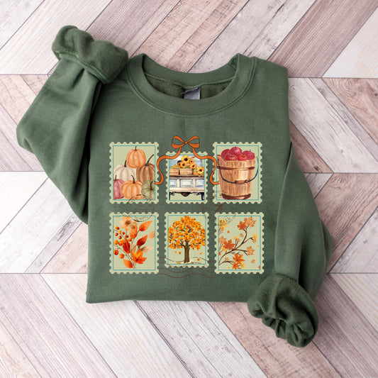 Green sweatshirt with autumn-themed design on a wooden surface