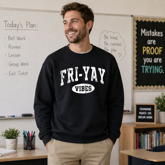 Man wearing a black sweatshirt with 'FRI-YAY VIBES' text in a classroom setting