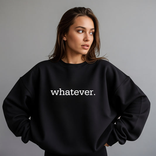 A woman wearing a black crewneck sweatshirt with the word 'whatever.' printed in white lowercase serif text across the chest, posed against a solid gray studio background.