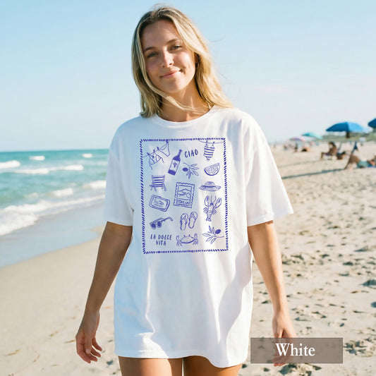 Woman wearing a white t-shirt with blue graphics on a beach