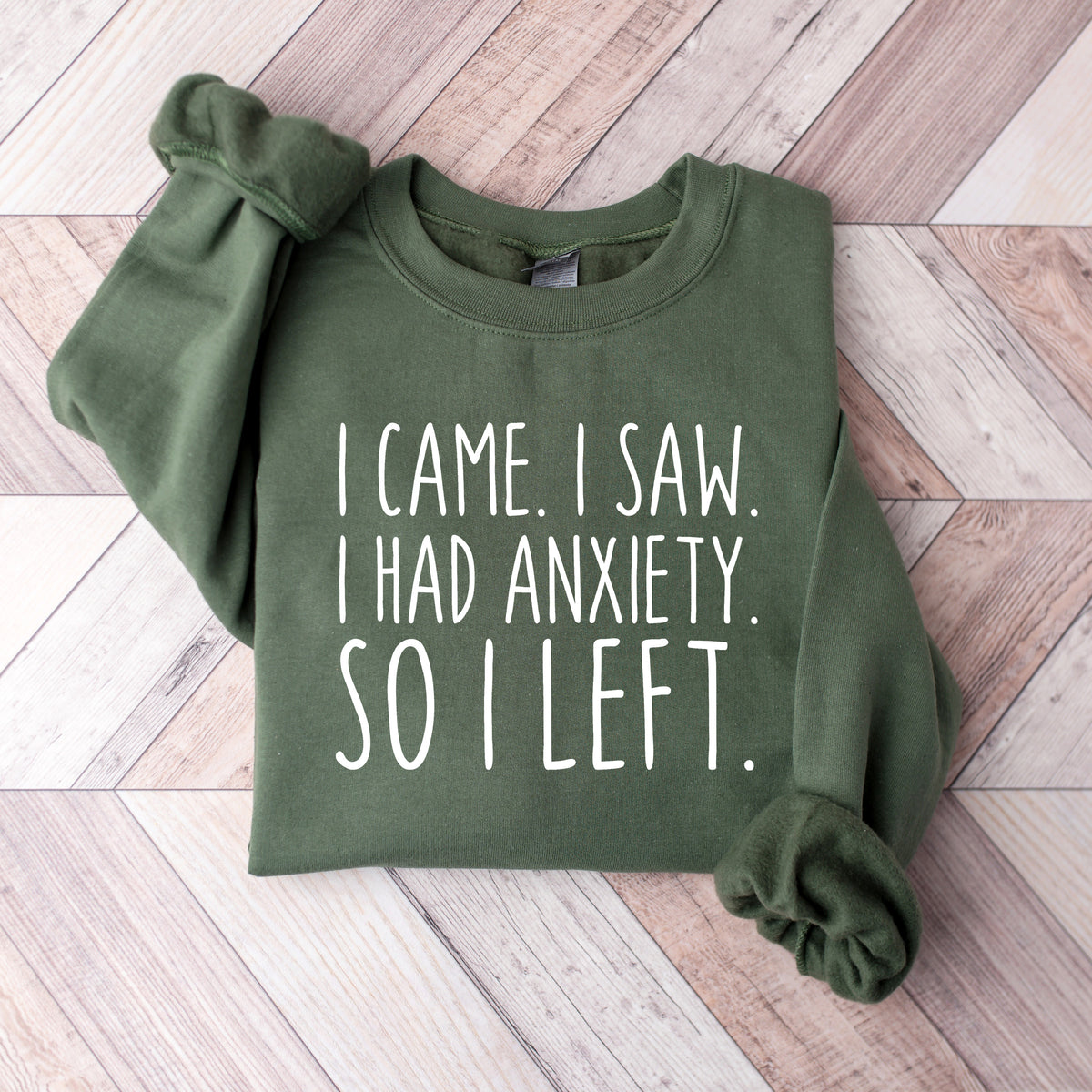 A military green sweatshirt that says 'I Came I Saw I Had Anxiety So I Left.'