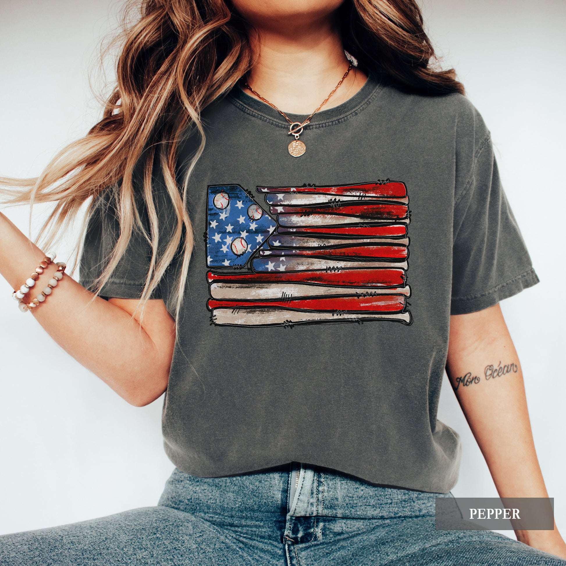 Person wearing a gray t-shirt with an American flag design, standing against a white background.