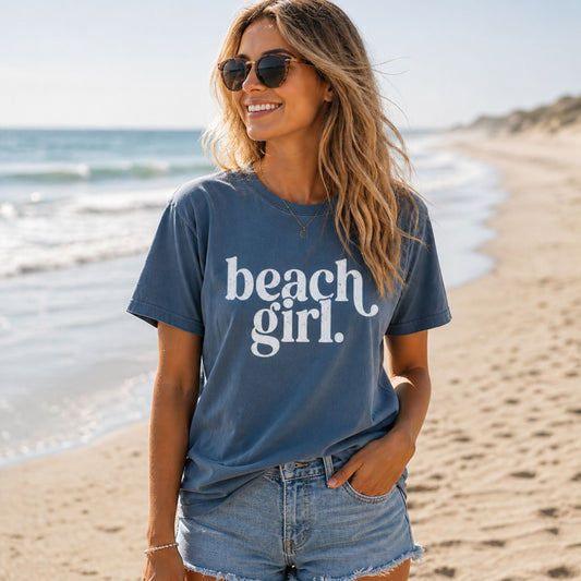 Woman wearing a 'beach girl' t-shirt on a beach