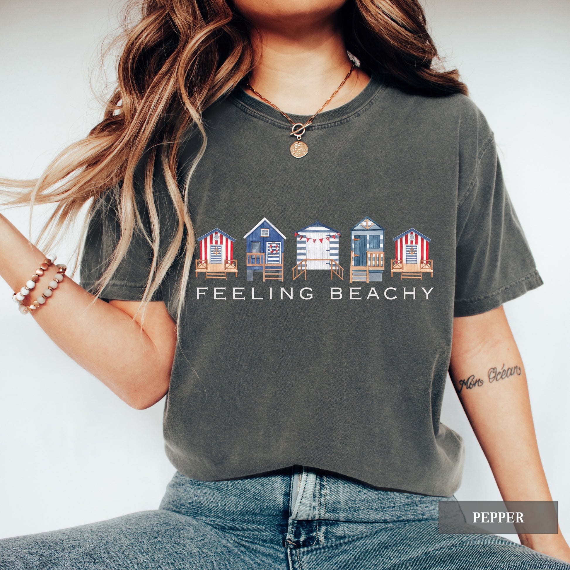 Person wearing a t-shirt with beach house design and 'Feeling Beachy' text.