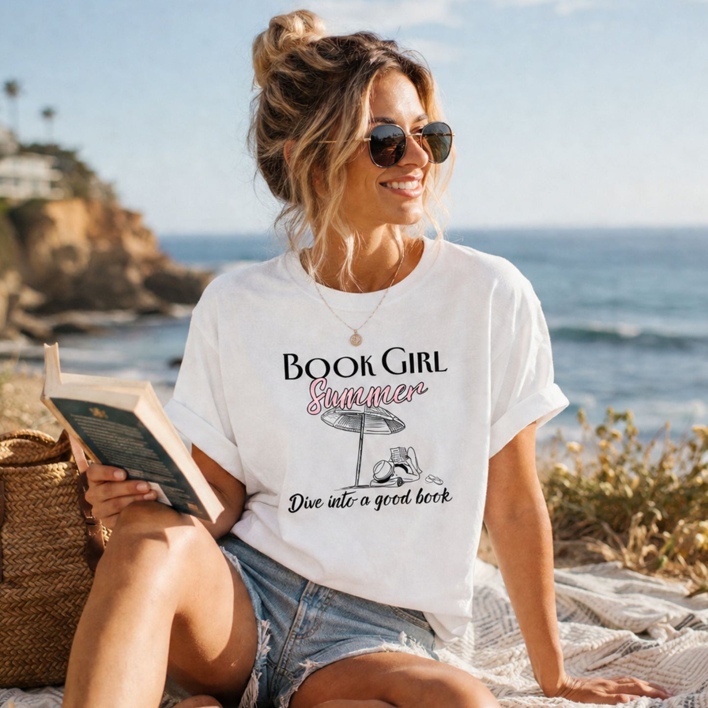Woman wearing a 'Book Girl Summer' t-shirt by the ocean.