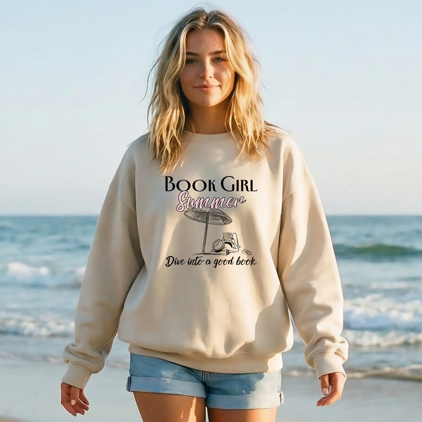 Woman wearing a 'Book Girl Summer' sweatshirt on a beach