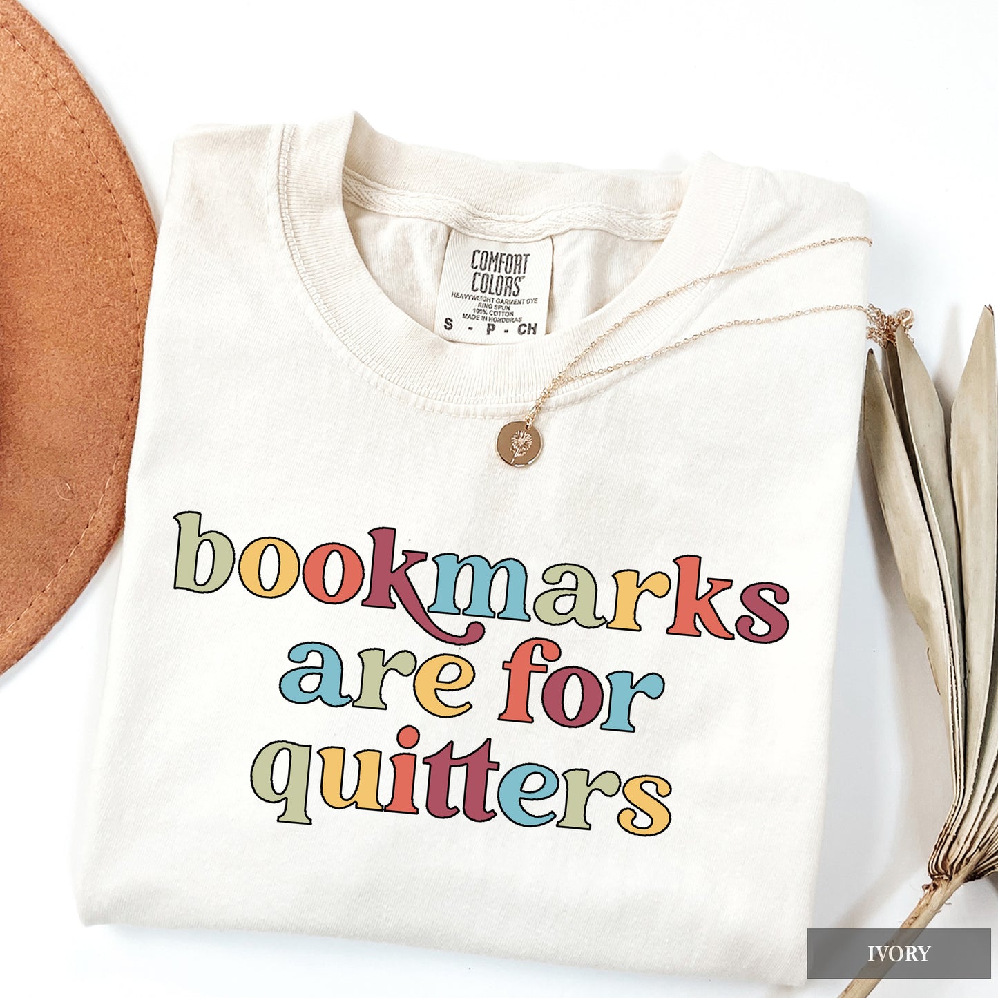 White sweatshirt with colorful text 'bookmarks are for quitters' on a white background