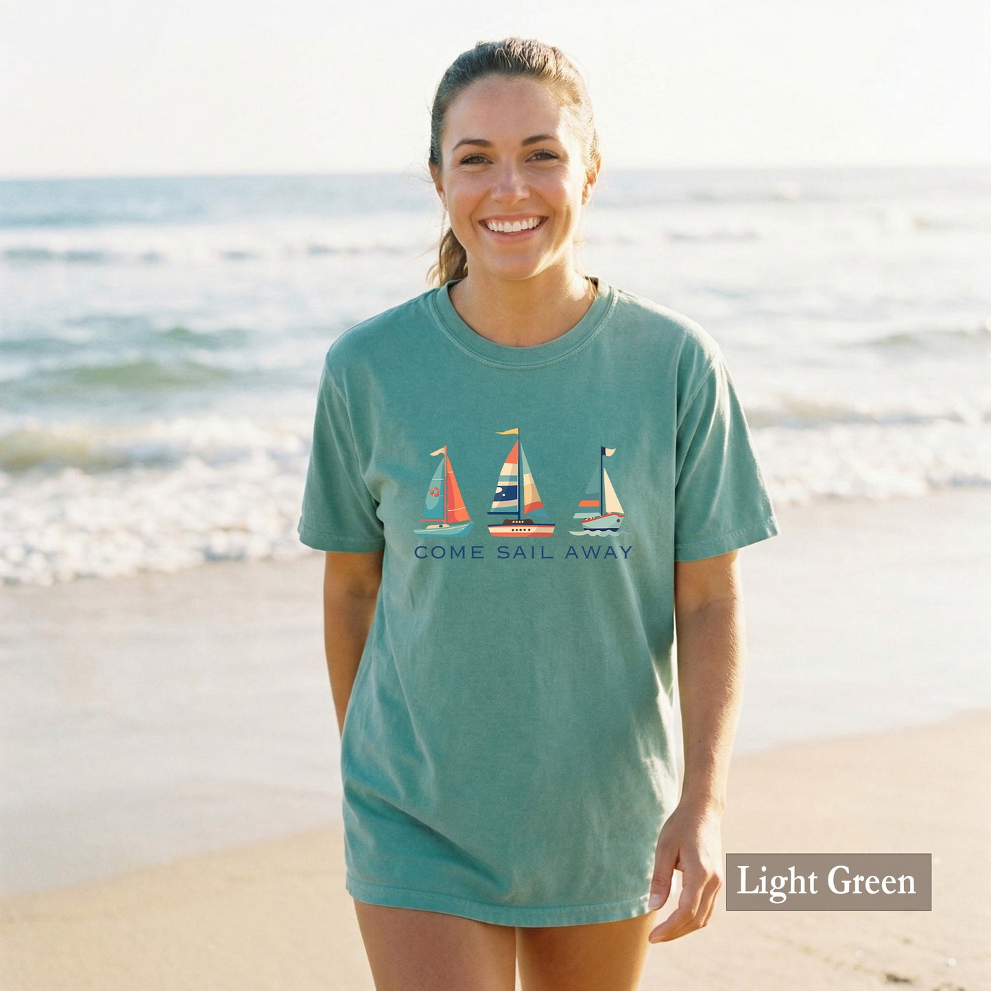 Woman wearing a light green t-shirt with sailboat design on a beach