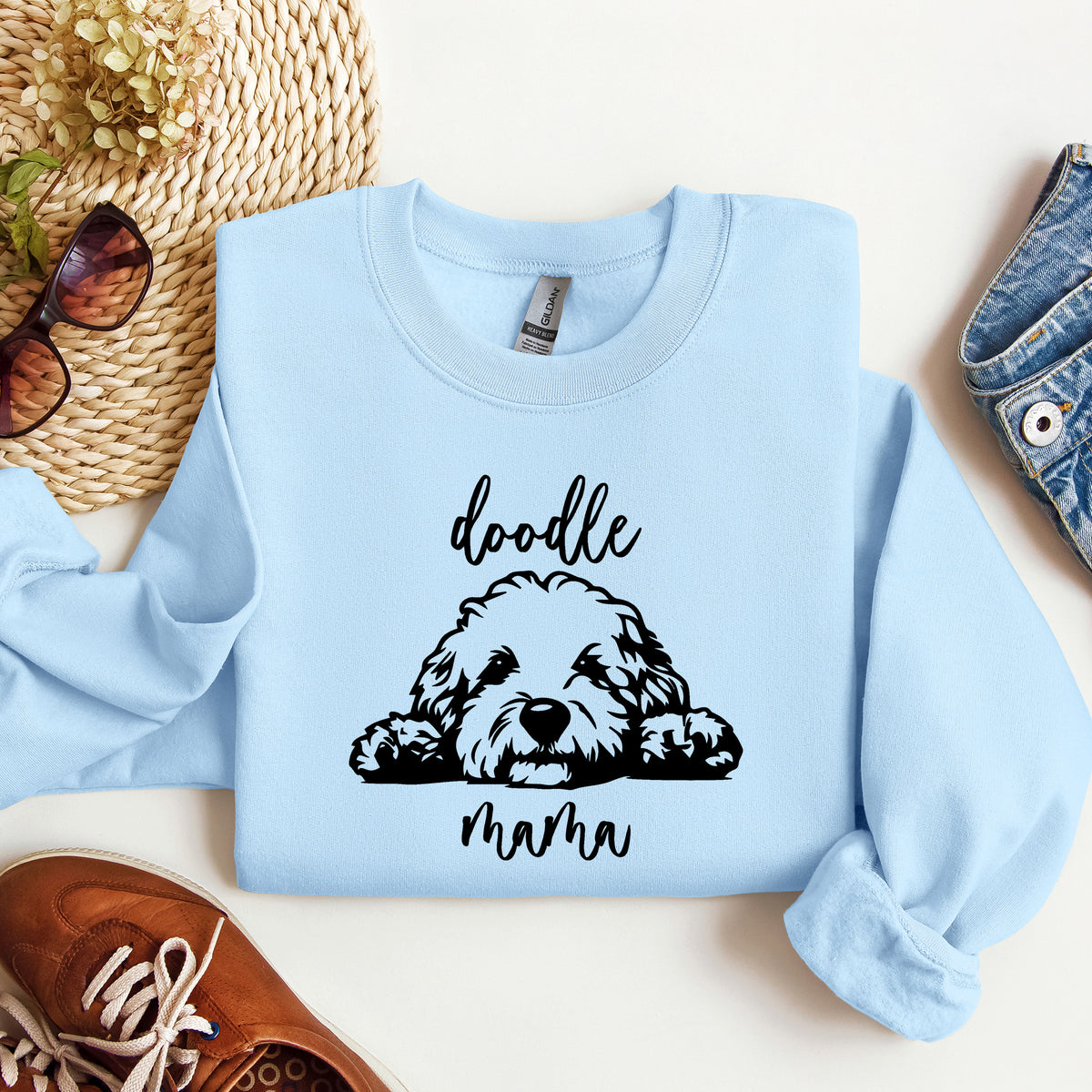 A light blue sweatshirt with 'doodle mama' and a picture of a goldendoodle on it.