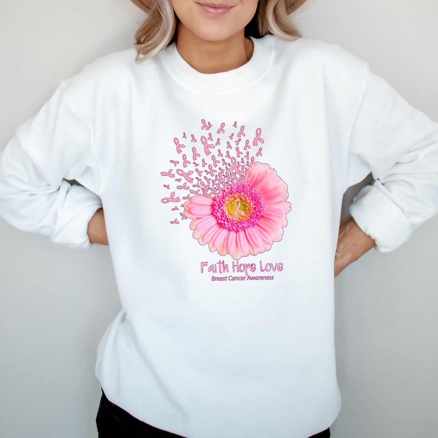 White sweatshirt with pink flower and 'Faith Hope Love' text on a gray background