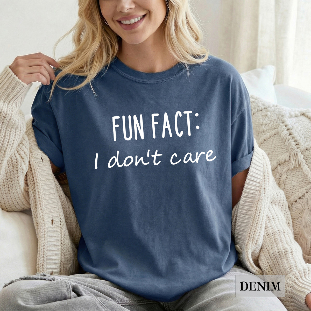 A woman wearing a denim comfort colors shirt that says 'Fun Fact: I don't care' on it.