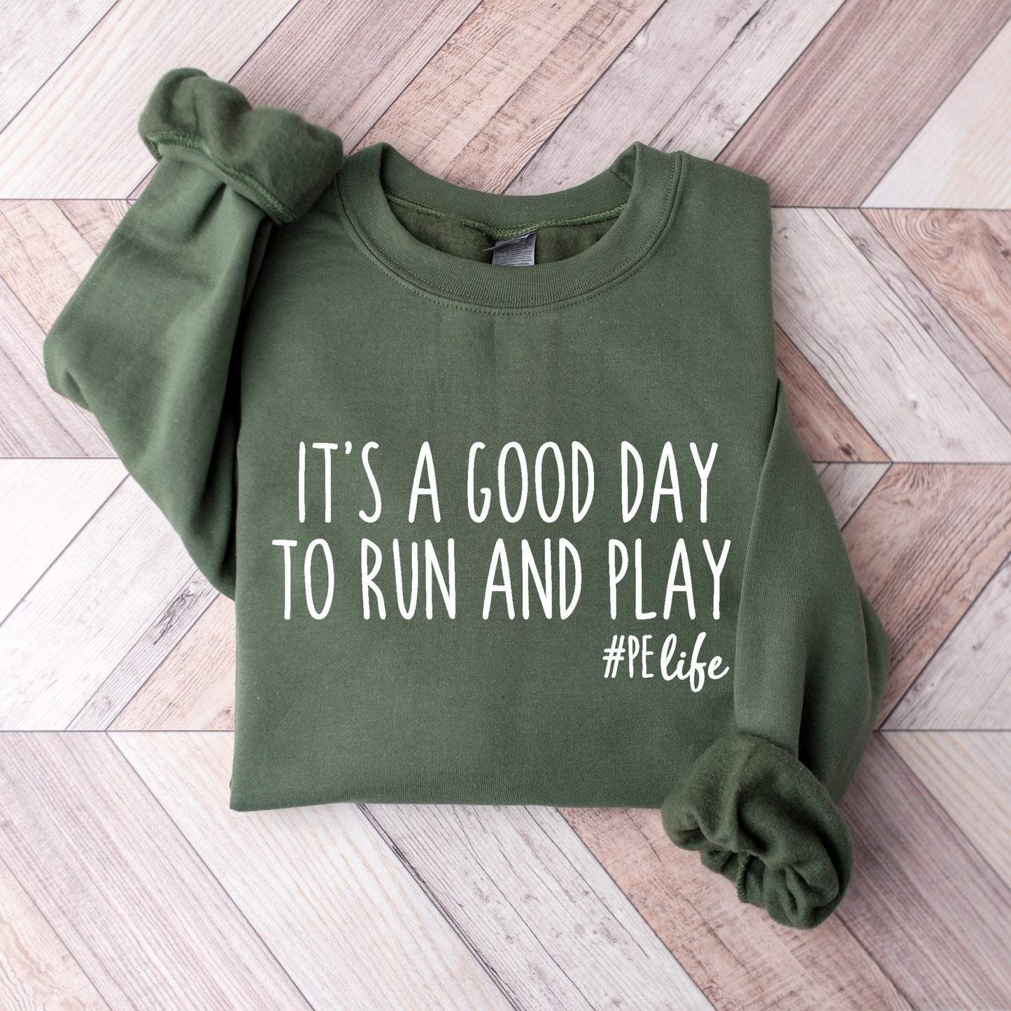 A military green Gildan sweatshirt that says It's a Good Day to Run and Play #PE life