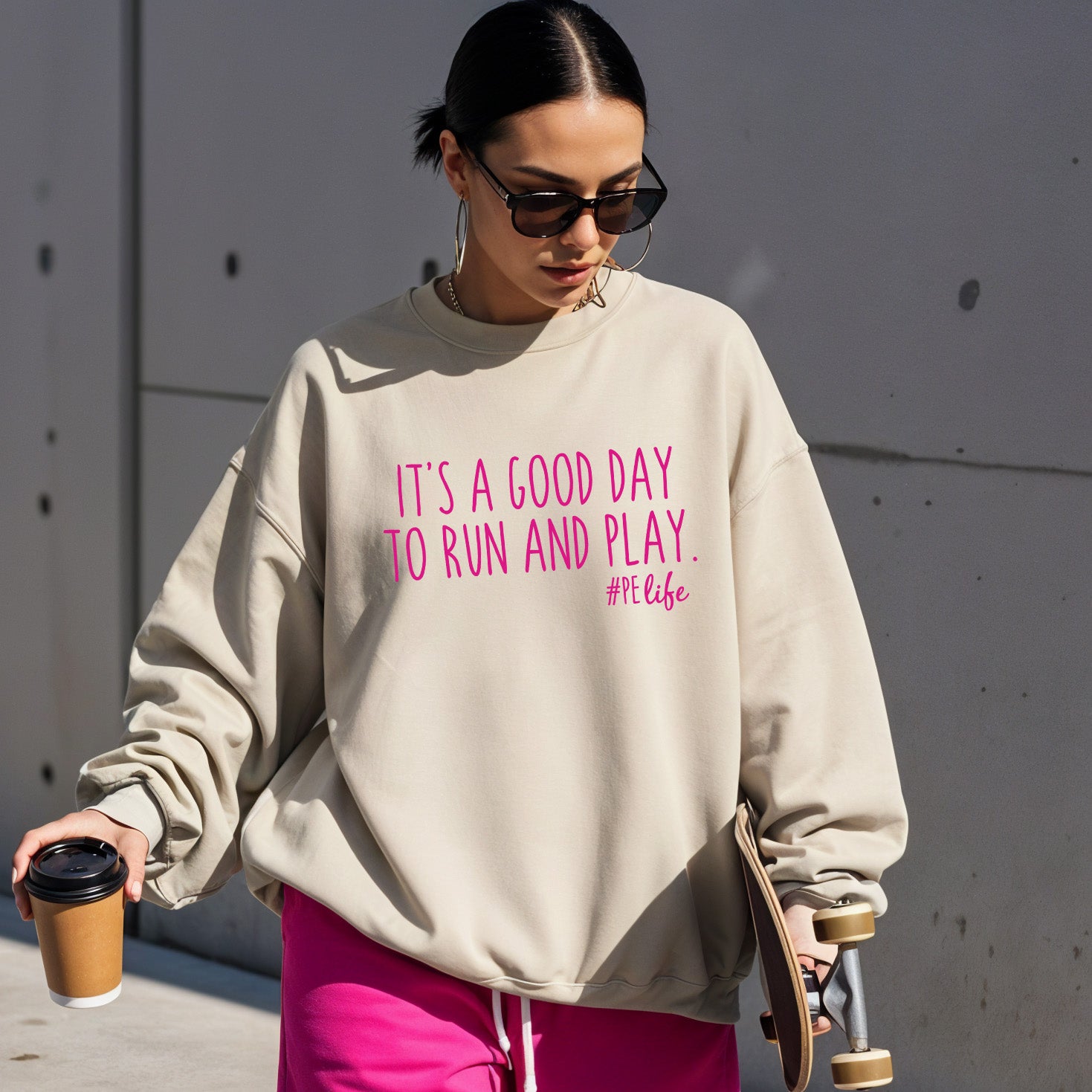 Woman wearing a sand Gildan sweatshirt that says It's a Good Day to Run and Play #PE life