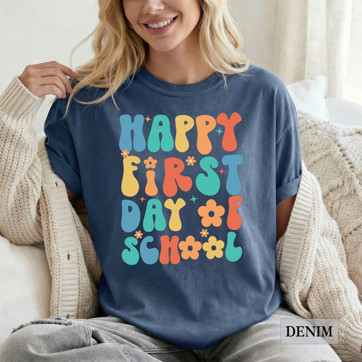 Person wearing a navy blue t-shirt with colorful 'Happy First Day of School' text.