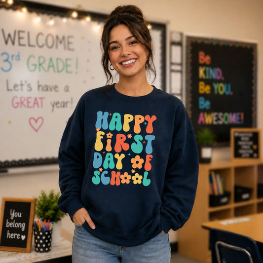 Person wearing a navy sweatshirt with colorful text on the first day of school in a classroom.