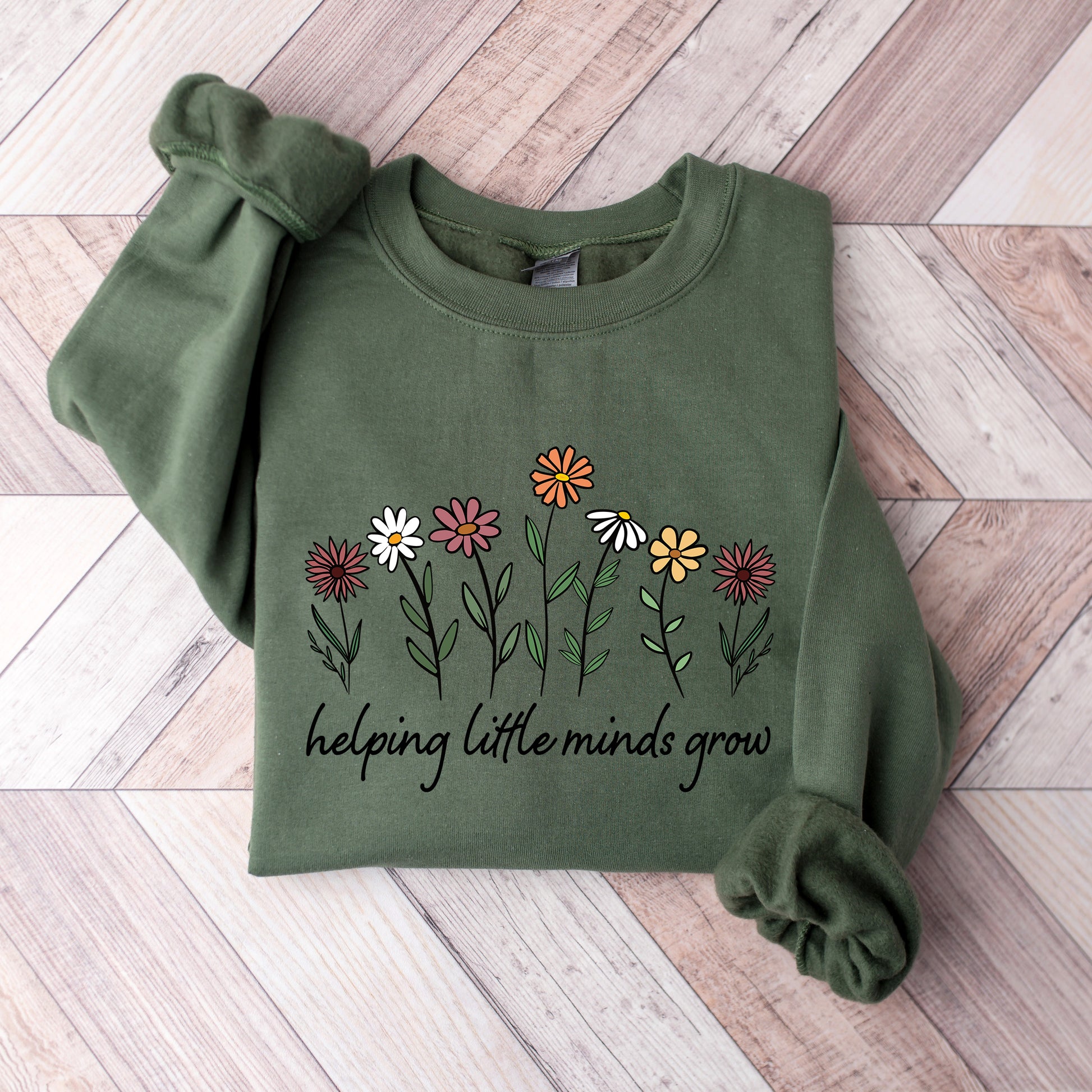 Green sweatshirt with a logo on a wooden floor