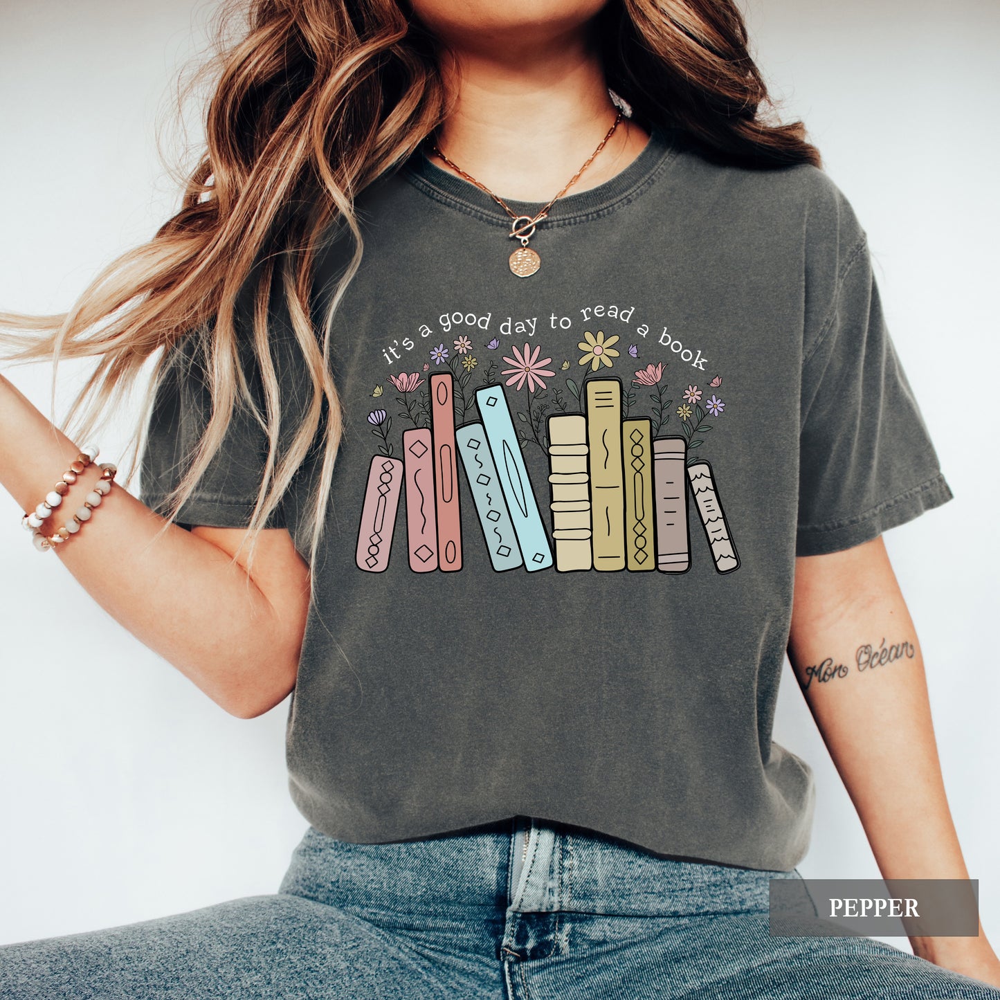Person wearing a graphic t-shirt with book design and text against a white background