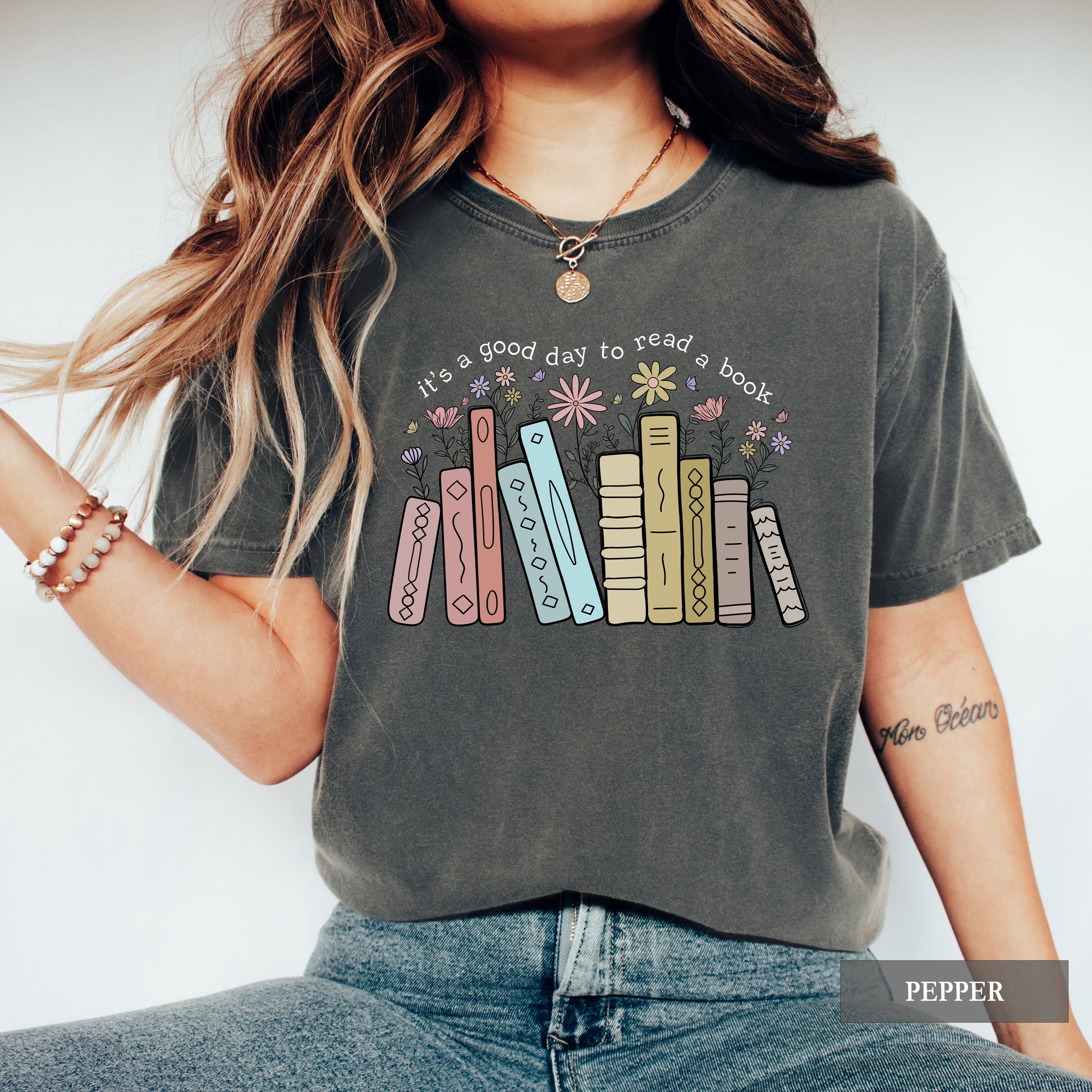 Person wearing a graphic t-shirt with book design and text against a white background