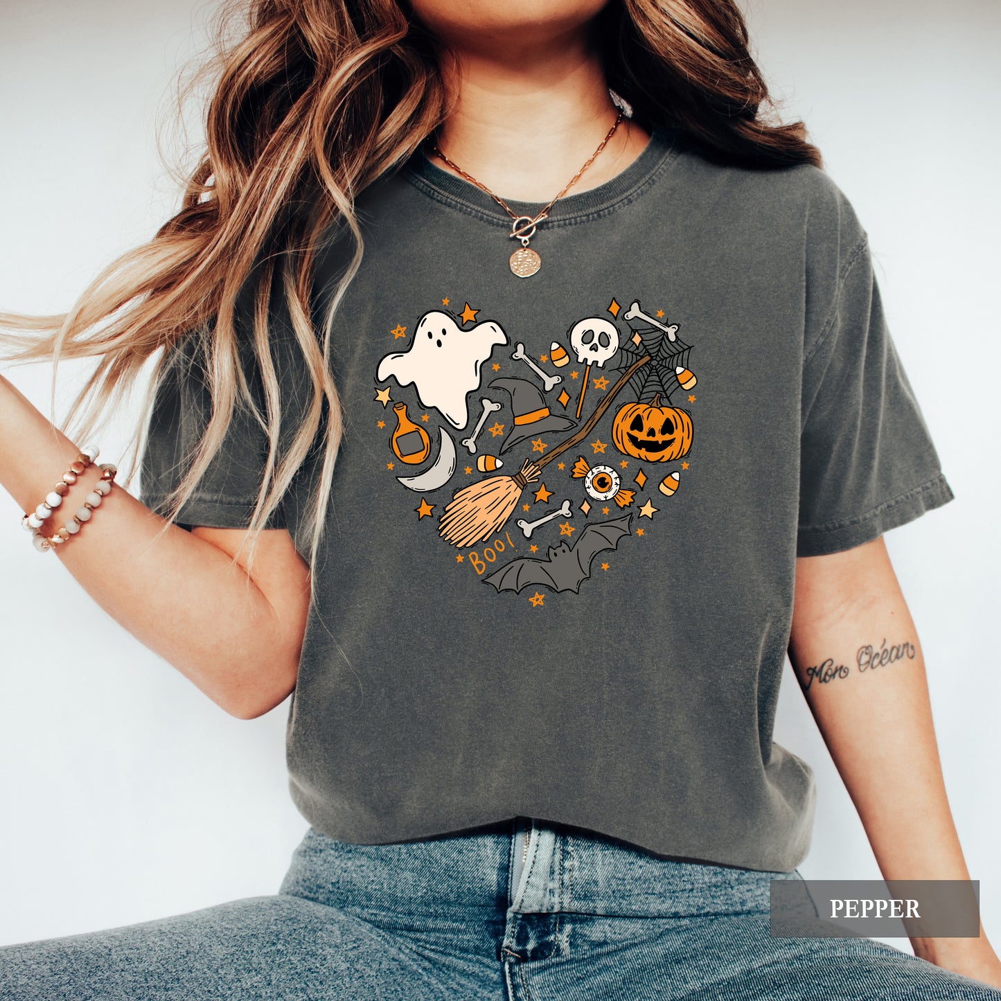 Person wearing a dark gray t-shirt with Halloween-themed graphics on a plain background