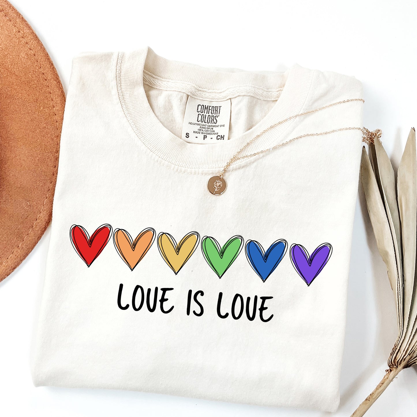 White sweatshirt with rainbow hearts and 'Love is Love' text on a white background