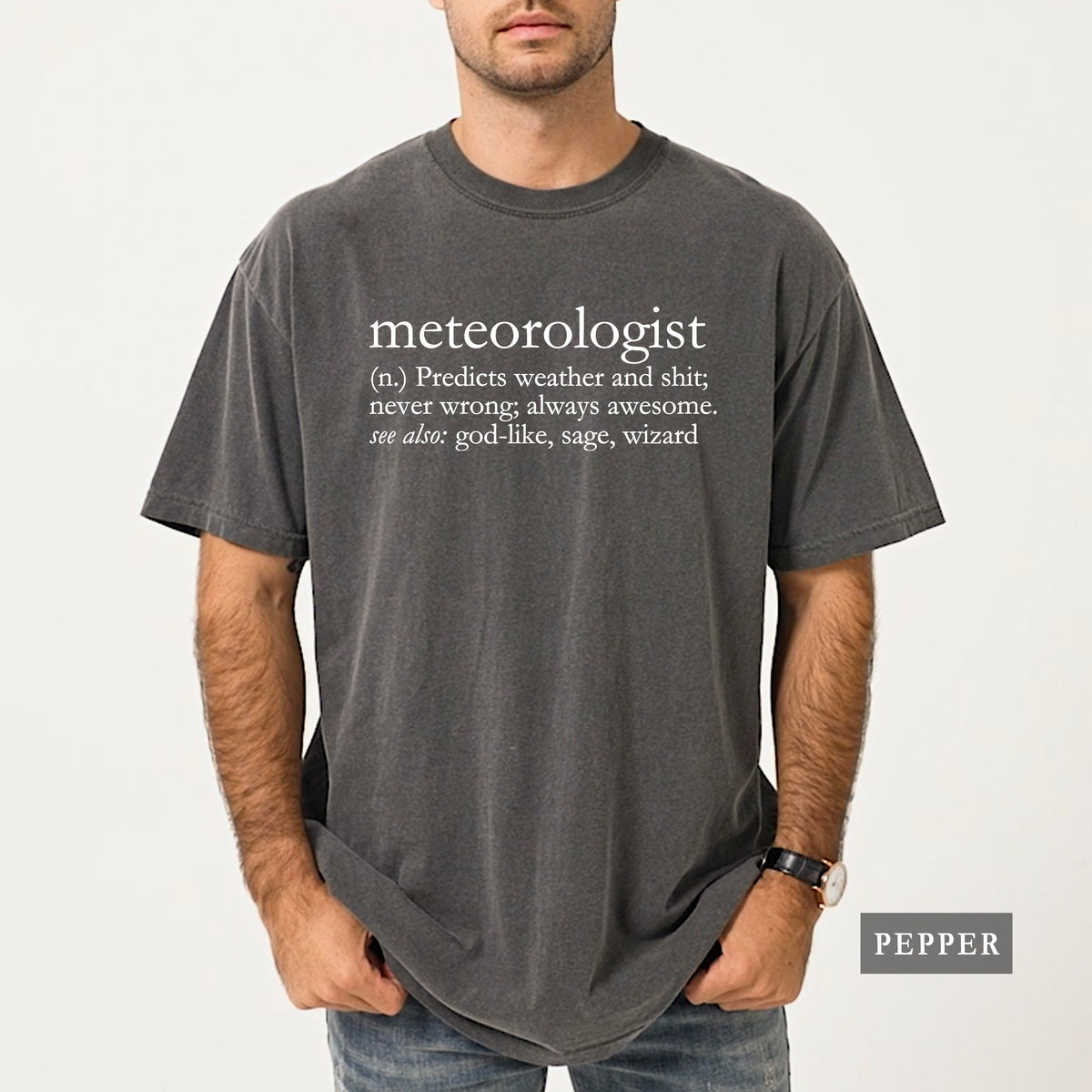 A man wearing a pepper comfort colors shirt that says 'meteorologist (n.) Predicts weather and shit; never wrong; always awesome. see also: god-like, sage, wizard