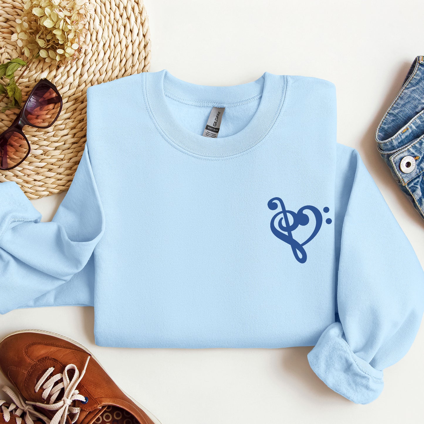 A light blue gildan sweatshirt with a musical note shaped like a heart on the pocket area.
