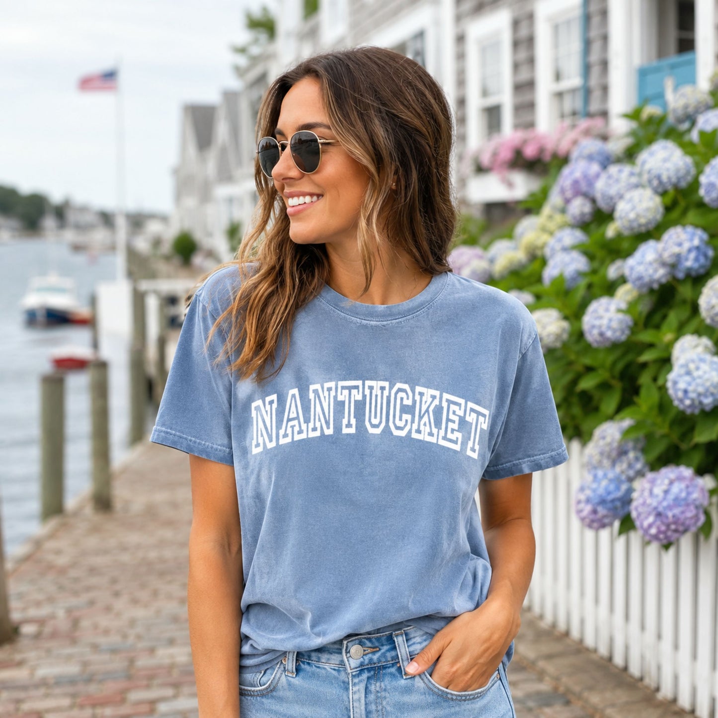 Woman wearing a blue jean comfort colors shirt that says Nantucket.