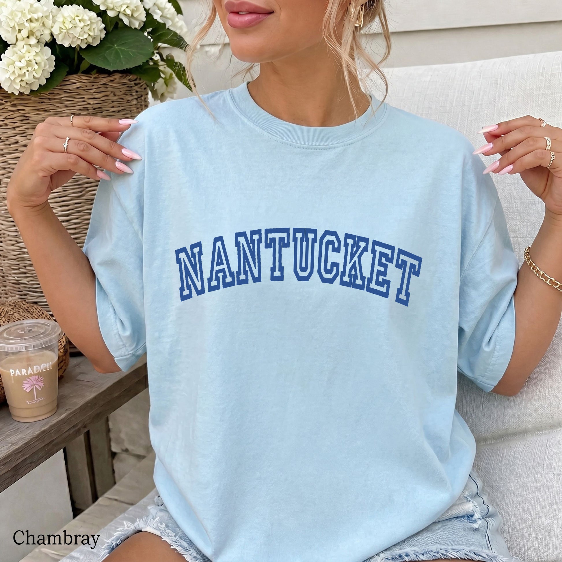 Woman wearing a chambray comfort colors shirt that says Nantucket.