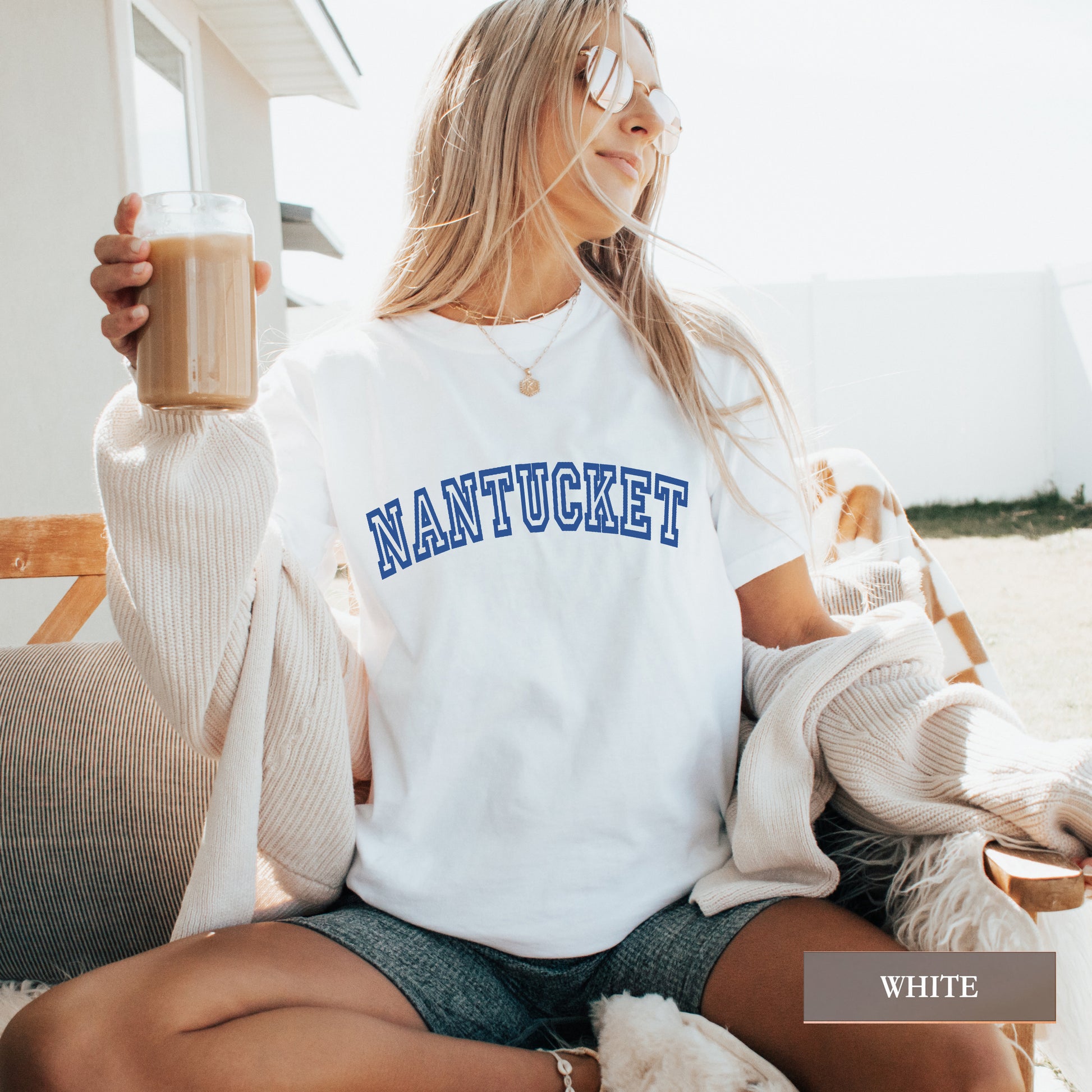 Woman wearing a white comfort colors shirt that says Nantucket.