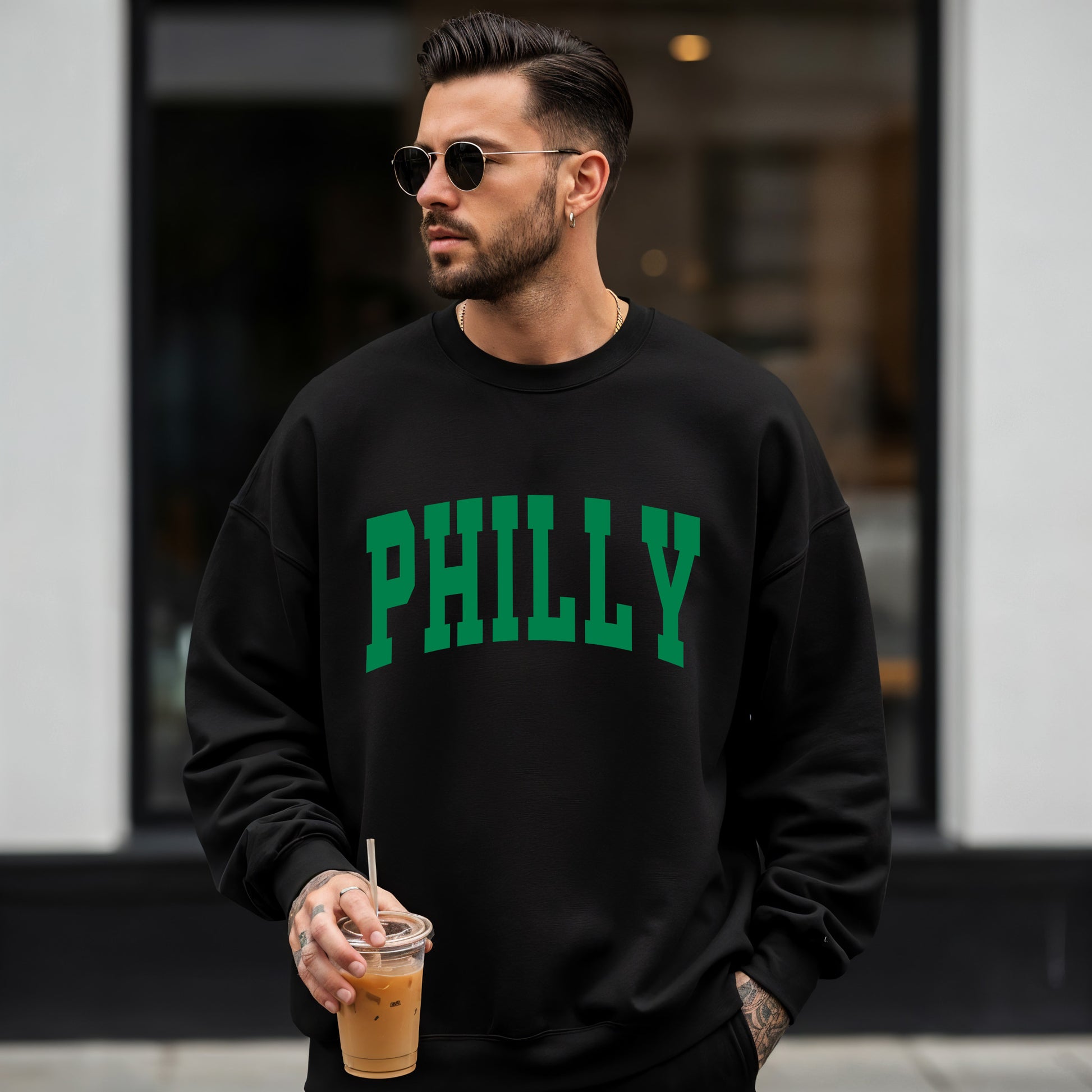 Man wearing a black Gildan sweatshirt with Philly on the front.