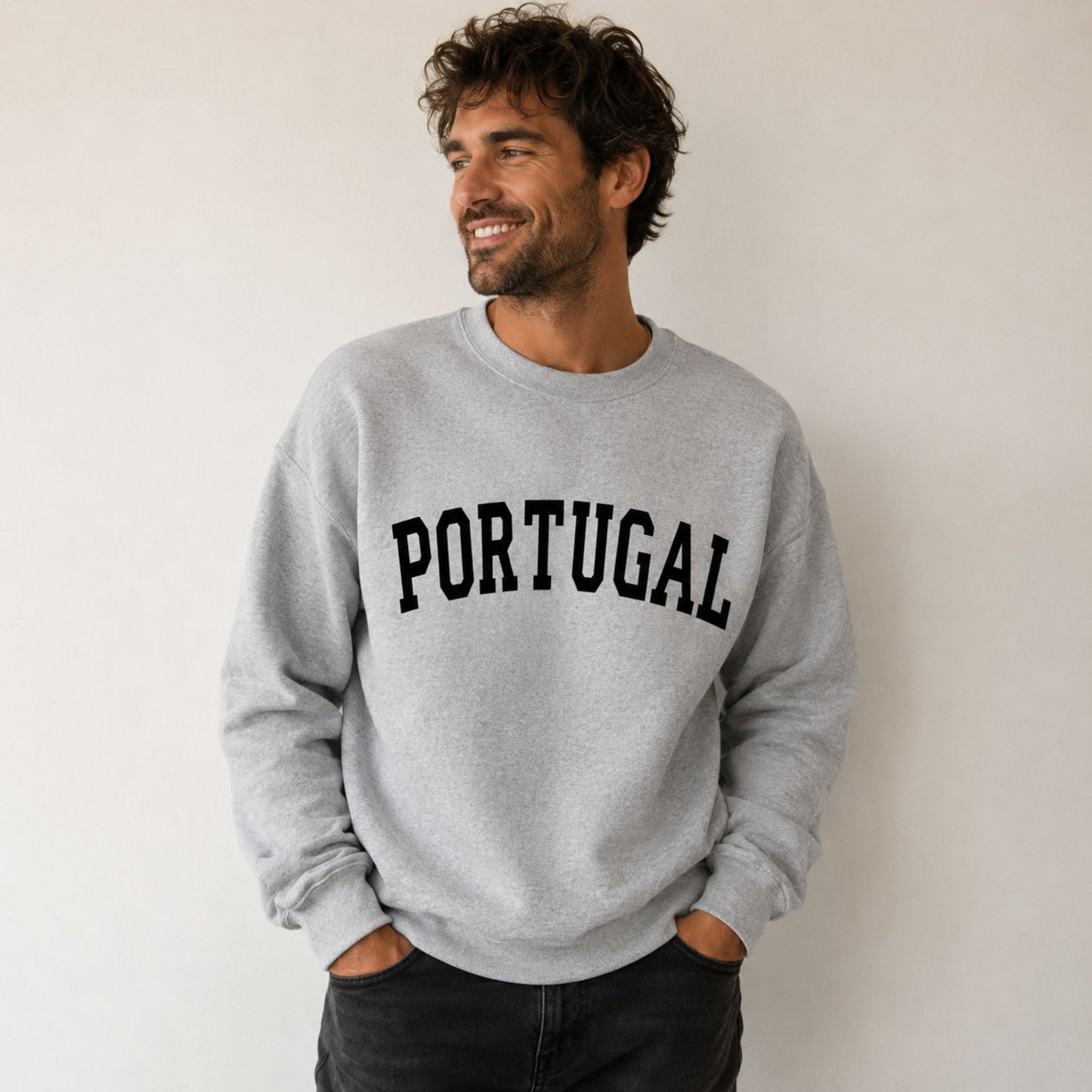 Man wearing a gray sweatshirt with 'PORTUGAL' printed on it against a plain background
