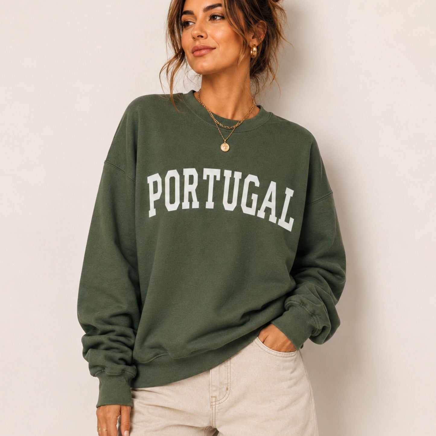Woman wearing a green sweatshirt with 'PORTUGAL' text against a plain background