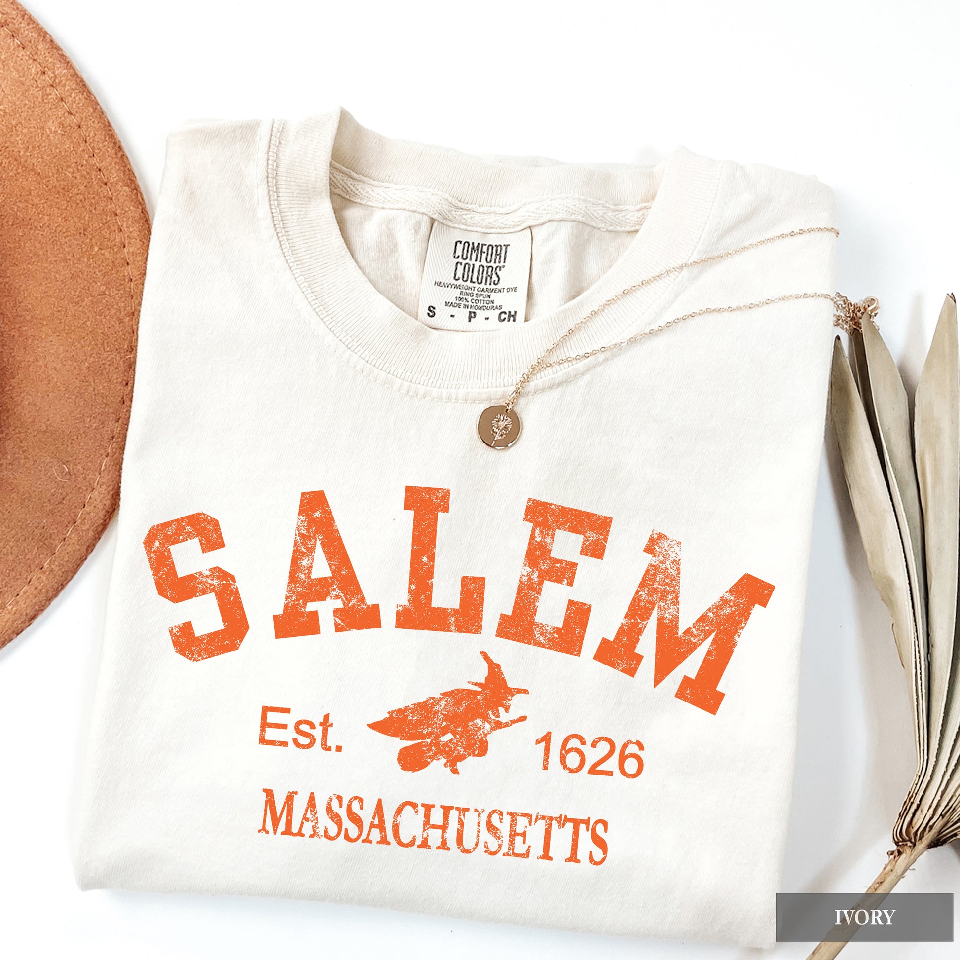 White Comfort Colors t-shirt with 'Salem, Massachusetts' text and witch graphic on an ivory background