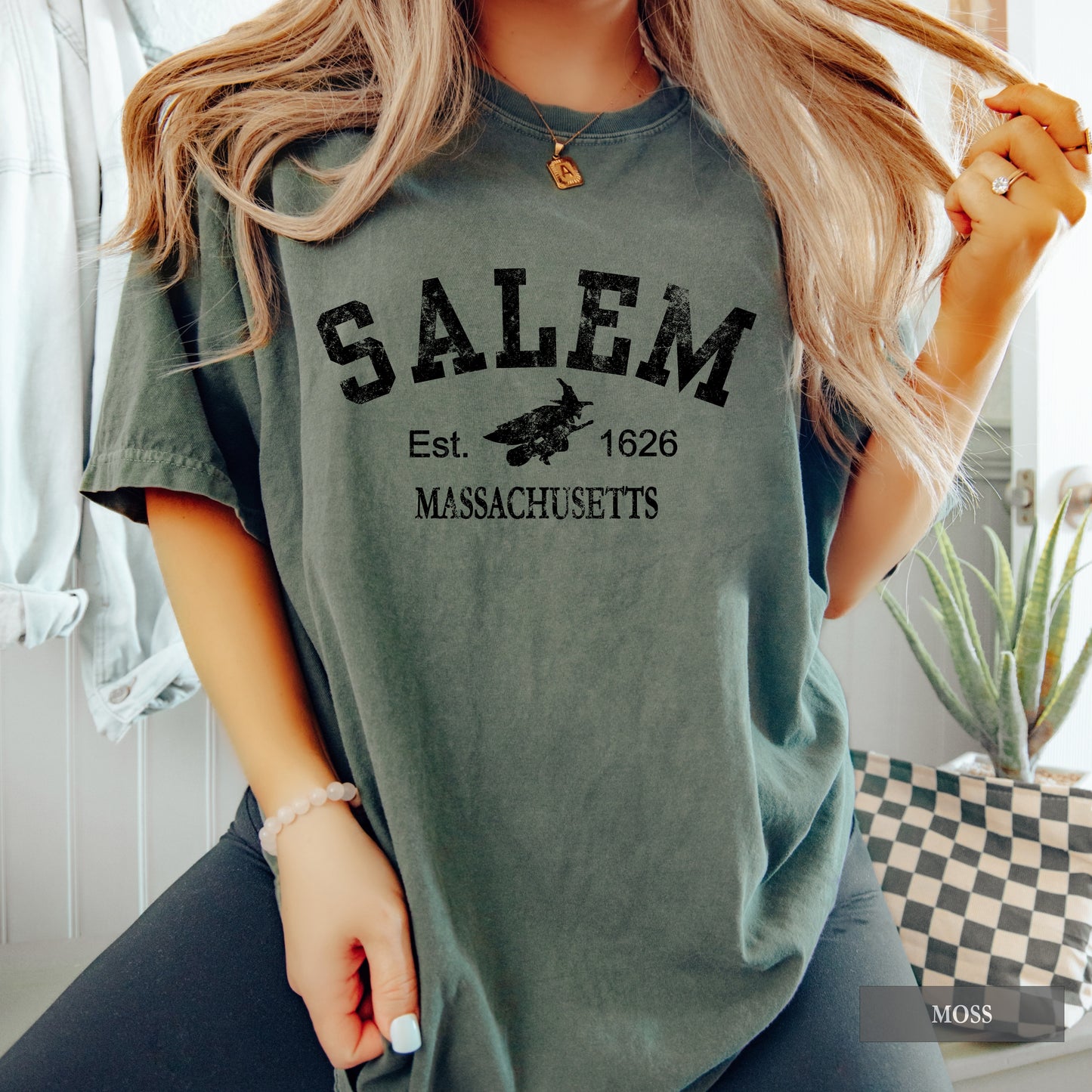 Person wearing a green t-shirt with 'Salem, Massachusetts' text and logo.