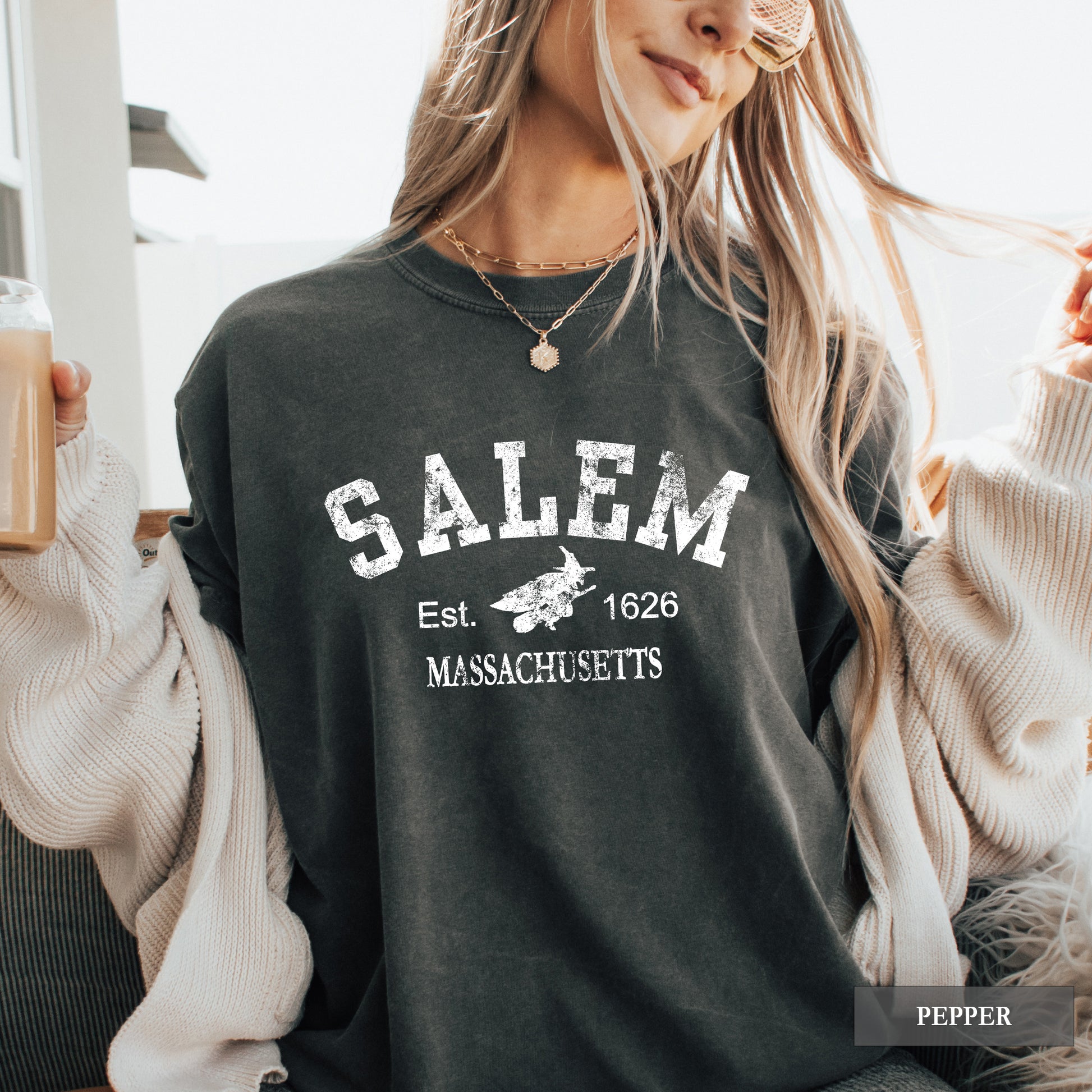 Person wearing a black sweatshirt with 'Salem, Massachusetts' text and graphics.