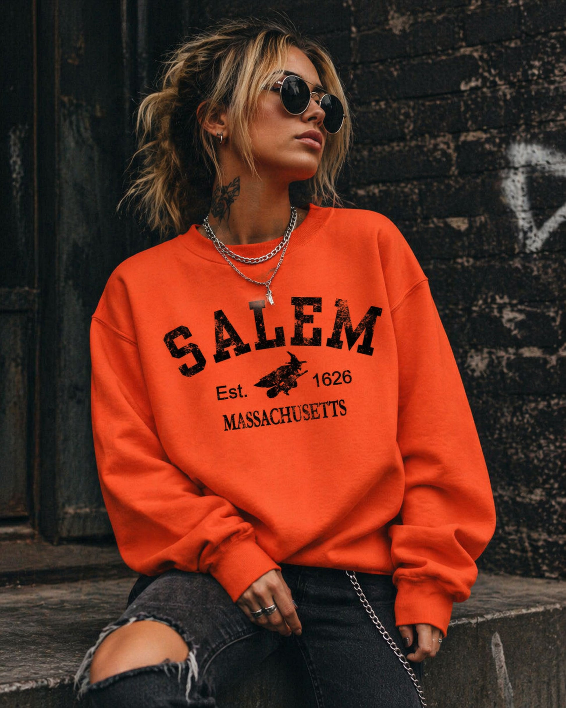 Person wearing an orange sweatshirt with 'Salem, Massachusetts' text against a dark wall.