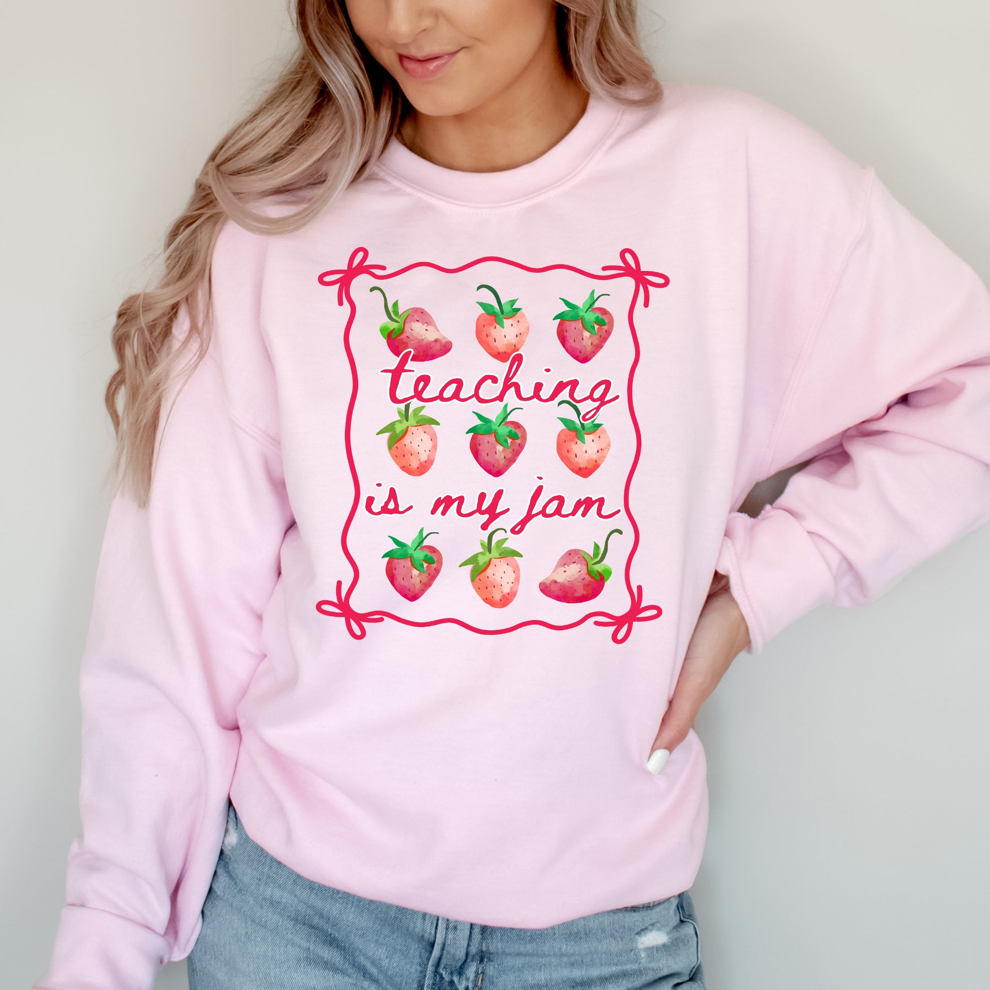 Person wearing a pink sweatshirt with 'teaching is my jam' design.