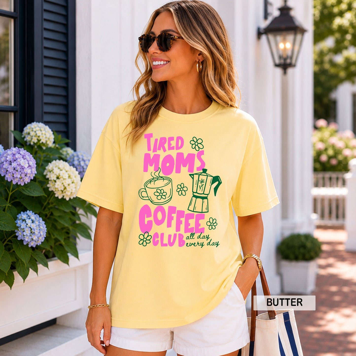 Woman wearing a yellow t-shirt with a coffee-themed design, standing outdoors.