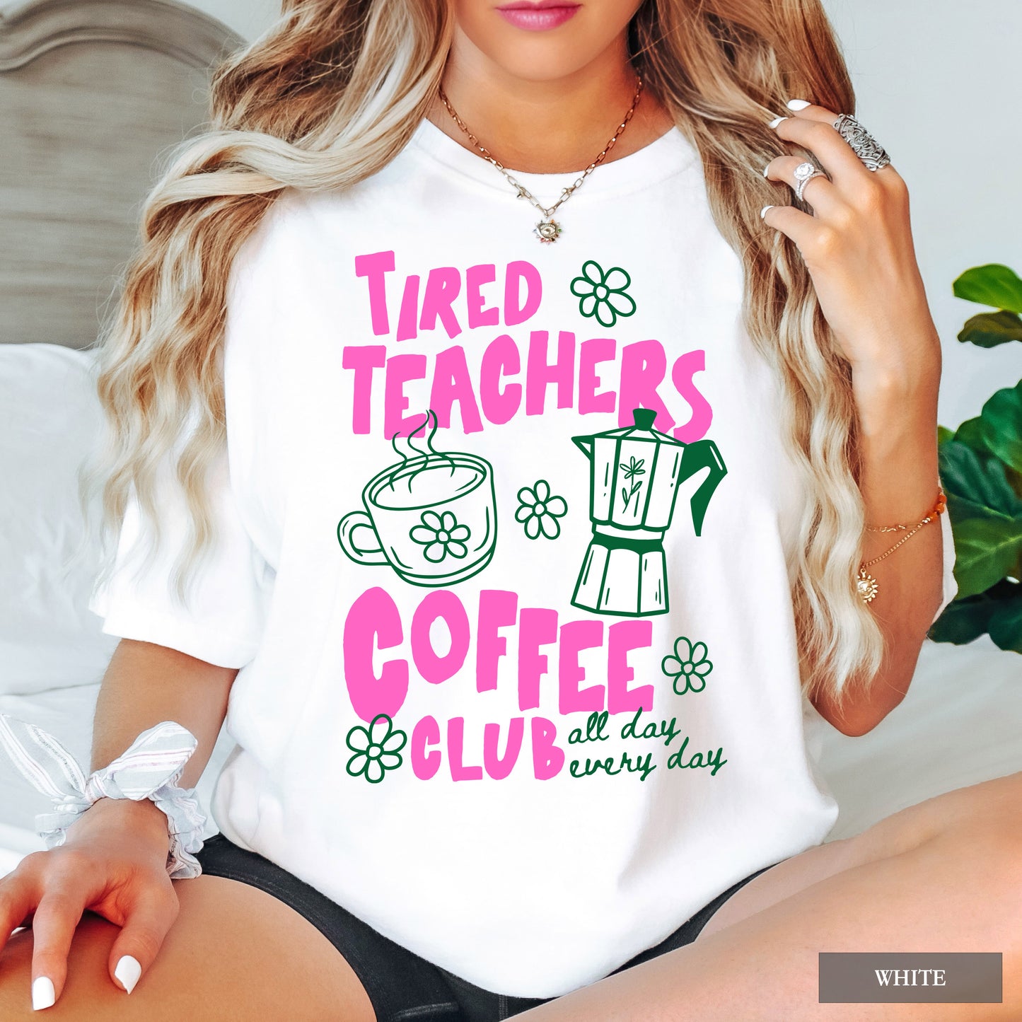 Person wearing a white t-shirt with 'Tired Teachers Coffee Club' design.