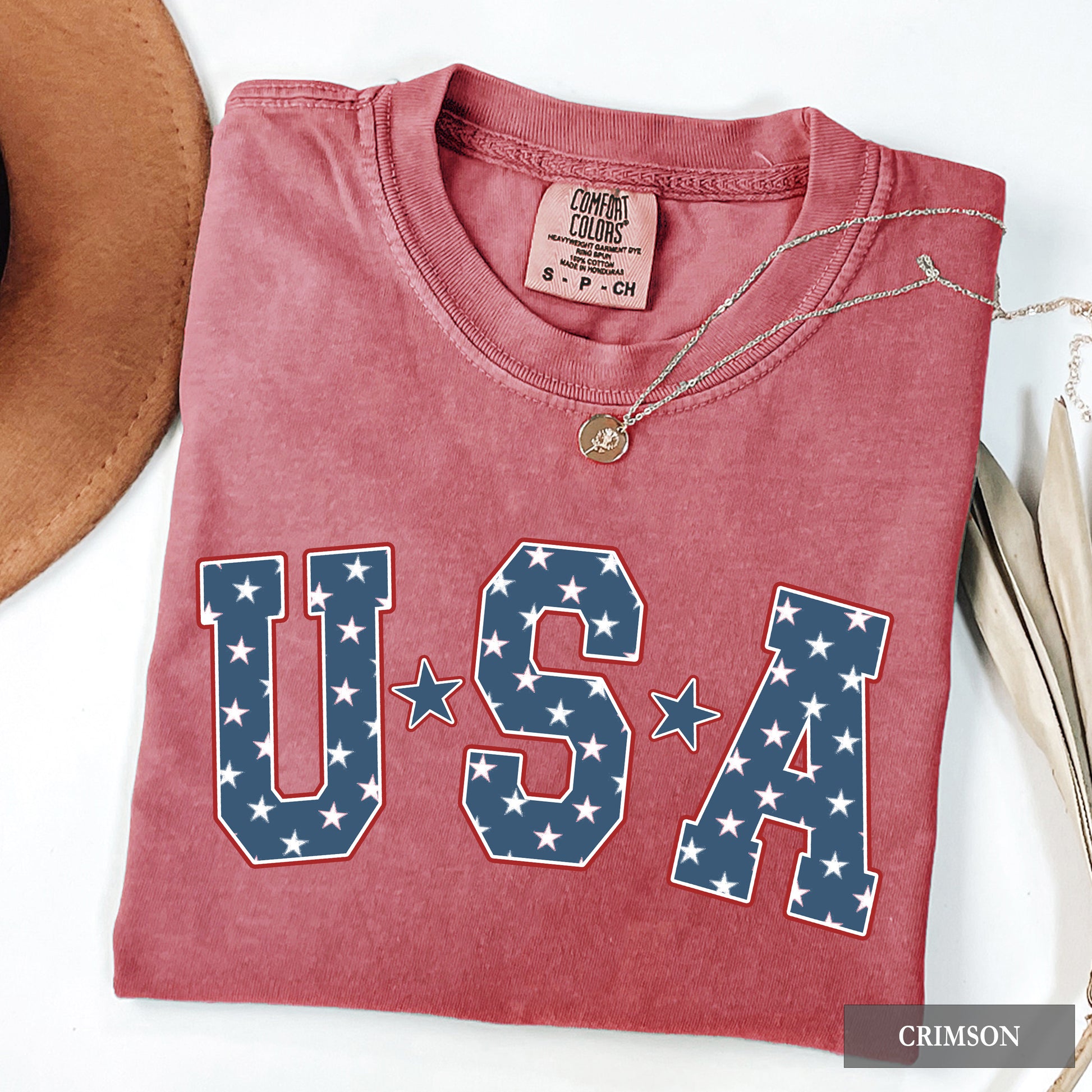 Folded red t-shirt with 'USA' design on a white surface